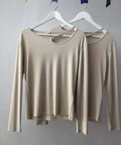 Jersey beige elegante con cadena dorada