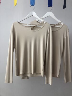 Jersey beige elegante con cadena dorada