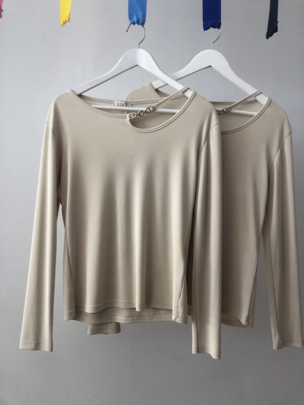 Jersey beige elegante con cadena dorada