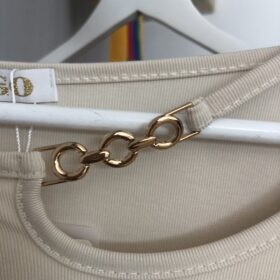 Jersey beige elegante con cadena dorada