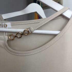 Jersey beige elegante con cadena dorada