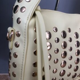 Bolso amarillo pastel con tachuelas doradas estilo chic