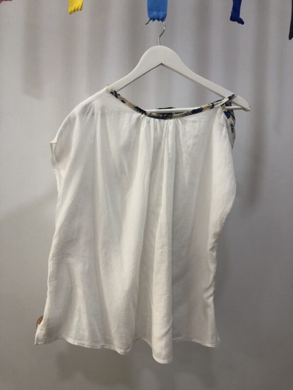 Blusa blanca con borde estampado y hombro al aire